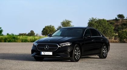 English: A black Mercedes-Benz E-Class luxury sedan parked on a sunny day in the Algarve Português: Um sedan de luxo preto Mercedes-Benz Classe E estacionado num dia de sol no Algarve