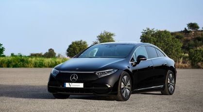 English: A black Mercedes-Benz EQS luxury electric car parked outdoors, representing sustainable and eco-friendly transport Português: Um carro elétrico de luxo preto Mercedes-Benz EQS estacionado ao ar livre, representando transporte sustentável e ecológico