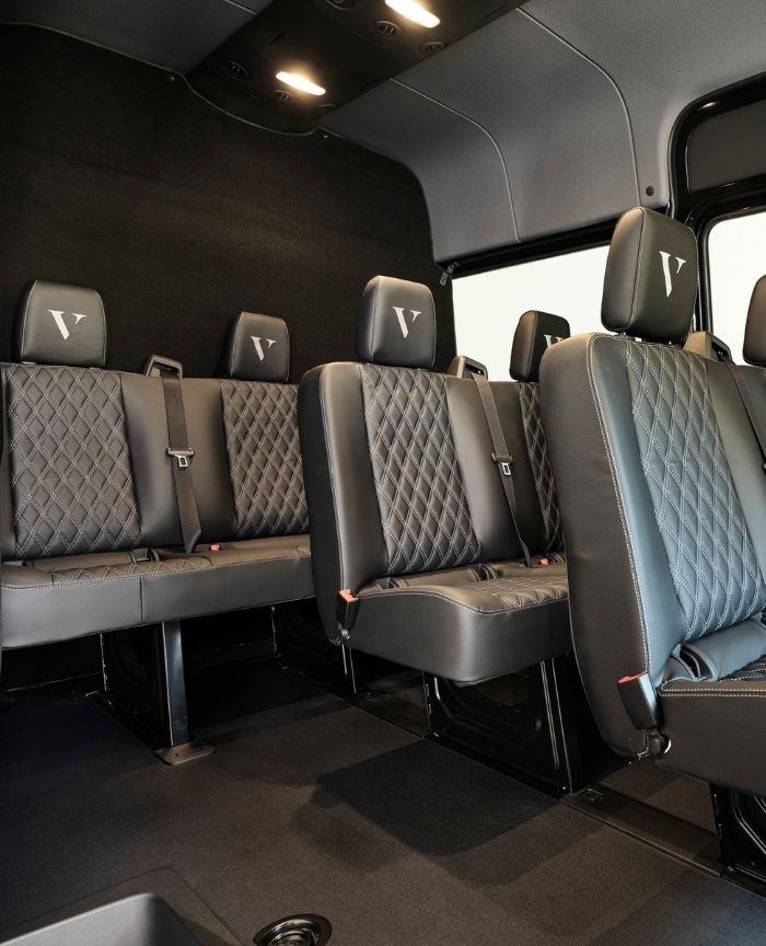 English: The spacious interior of a black luxury van with quilted leather seats and the VIP Chauffeurs logo embroidered on the headrests Português: O interior espaçoso de uma carrinha de luxo preta com bancos de couro acolchoados e o logotipo da VIP Chauffeurs nos encostos de cabeça