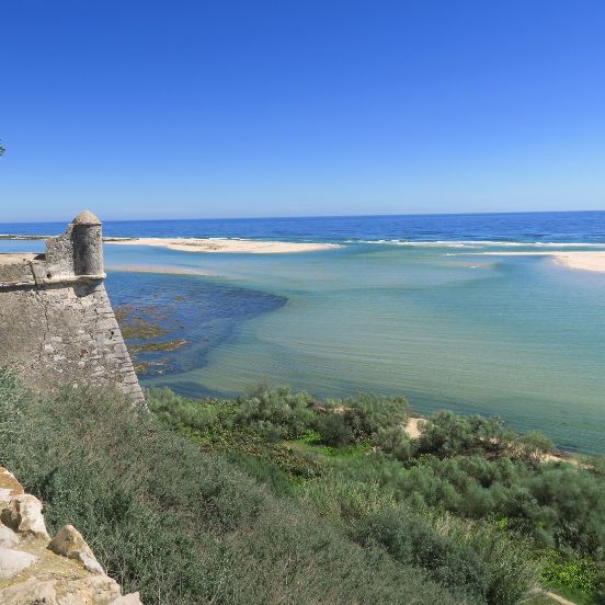 A coastal fort overlooking the Ria Formosa natural park with its sandbanks and clear turquoise water in the Algarve. Um forte costeiro com vista para o Parque Natural da Ria Formosa, com os seus bancos de areia e águas claras no Algarve.