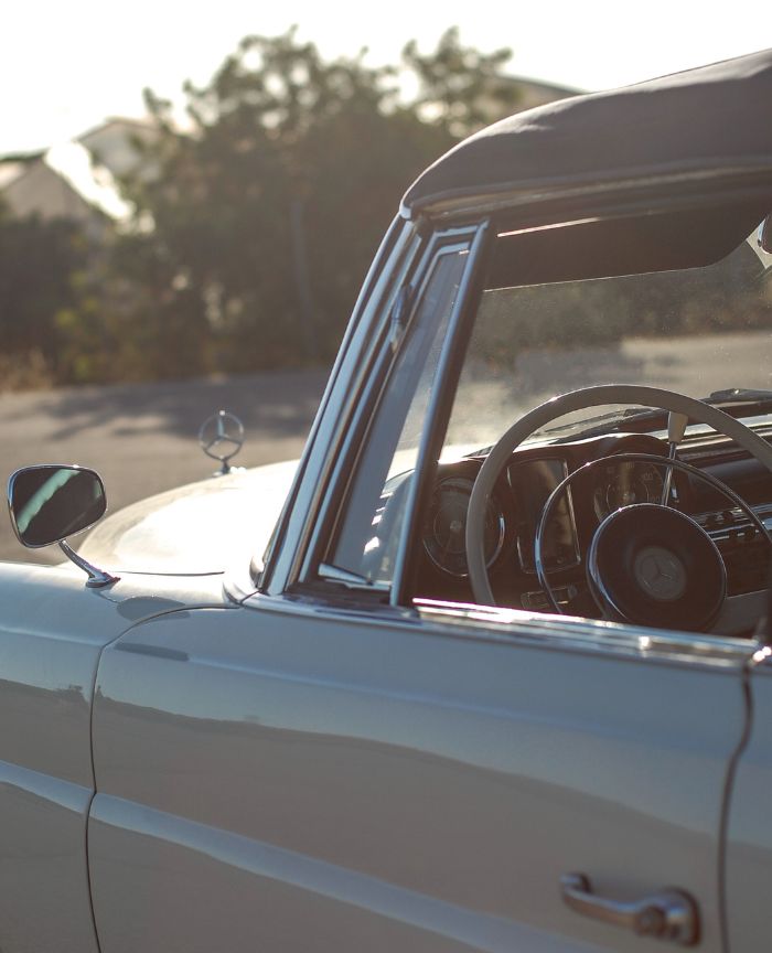 English: A close-up of a vintage Mercedes-Benz convertible, showing the chrome details and steering wheel on a sunny day Português: Um close-up de um carro conversível clássico da Mercedes-Benz, mostrando os detalhes cromados e o volante num dia de sol